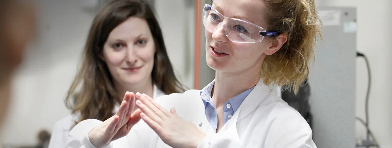 a woman with glasses and a woman with her hands up